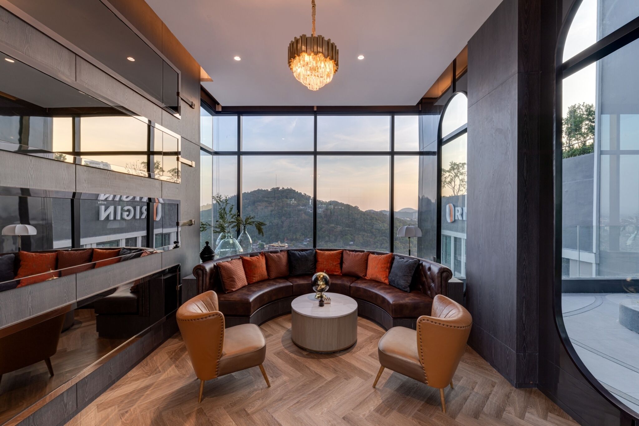 Un intérieur moderne avec un canapé en cuir aux lignes courbes, une table basse ronde et une grande fenêtre donnant sur la ville.