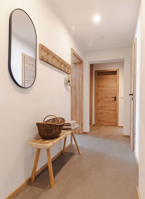 A hallway with a wooden bench, a mirror, and a coat rack. - Simon vacation apartment, 90 m², 2-6 persons, eat-in kitchen, 3 bedrooms, shower/WC + WC, balcony (Staudach-Egerndach)