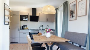 Une cuisine moderne avec un coin repas comprenant une table en bois, des chaises et un canapé.