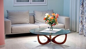 A living room with a glass coffee table, a sofa with patterned cushions, and a vase with flowers. - Villa Eudora Nafpaktos (Nafpaktos)