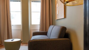 Ett modernt vardagsrum med en soffa, ett runt bord och en lampa.