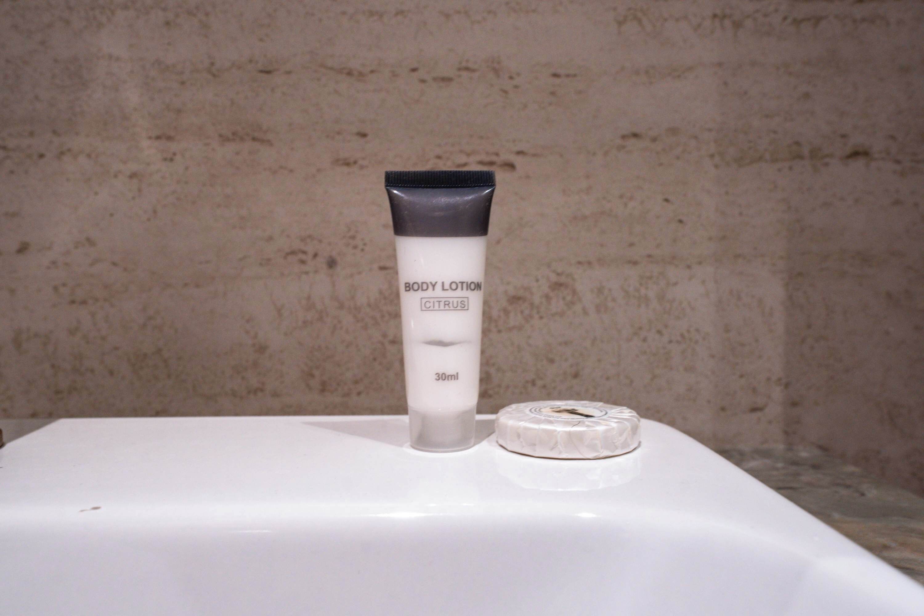 Eine Tube Körperlotion und ein kleiner runder Behälter auf weißem Untergrund.