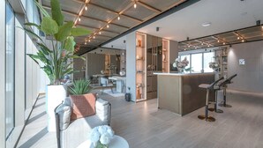 Een modern interieur met een bar in het midden, zitgedeeltes en een grote potplant.