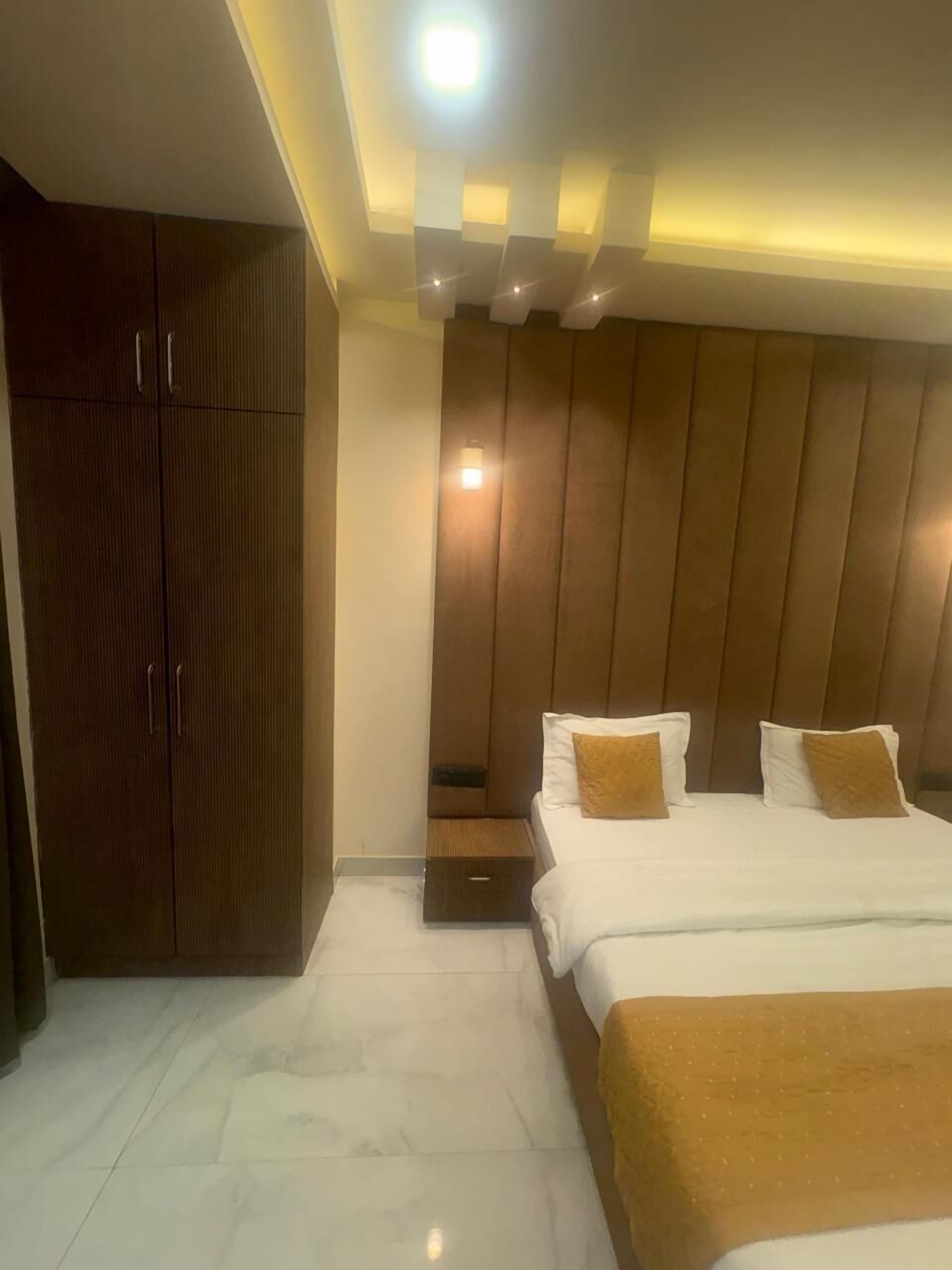 A hotel room with a bed, a wardrobe, and a nightstand.