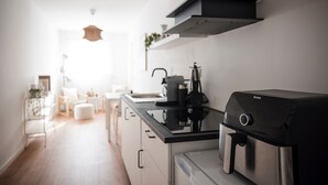 A modern kitchen with a black coffee maker, a stainless steel range hood, and a black appliance on the counter. - Luxury Apartment on the Edge of the Forest, Close to the City (Bornheim)