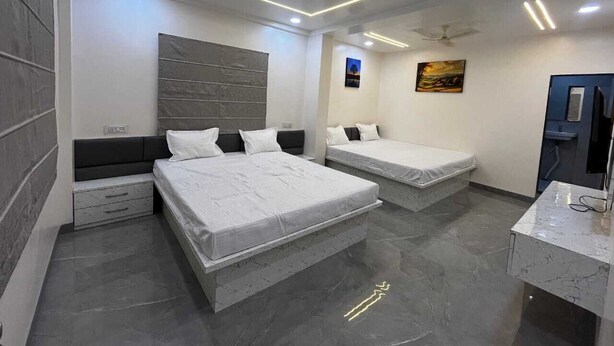 Un dormitorio moderno con dos camas, un armario empotrado y una cómoda con espejo.