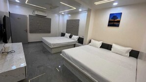 Una habitación de hotel moderna con dos camas, un escritorio de mármol y un televisor de pantalla plana.