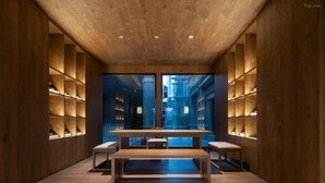 A modern interior with a wooden ceiling, a central table, and shelves on the walls. - Giorgio Morandi Hotel (Nanjing Yueyahu & NUAA) (Nanjing)