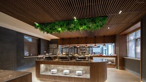 A modern kitchen with a central island, wooden ceiling, and green hanging plants. - Giorgio Morandi Hotel (Nanjing Yueyahu & NUAA) (Nanjing)