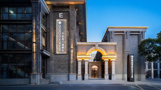 A hotel entrance with a prominent 'E' sign, a brick facade, and an arched doorway. - Giorgio Morandi Hotel (Nanjing Yueyahu & NUAA) (Nanjing)