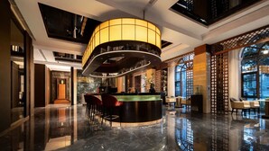 A modern lobby with a central reception desk, seating area, and large windows offering views. - Giorgio Morandi Hotel (Nanjing Yueyahu & NUAA) (Nanjing)