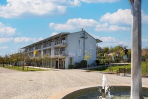 Ein Gebäude mit Balkon, Schild und Springbrunnen.