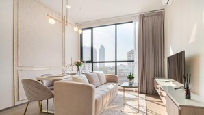Una sala moderna con sofá, mesa de comedor y televisor.