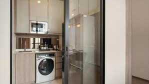Una cocina compacta con lavadora, microondas y refrigerador.