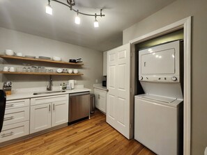 A compact kitchen with white cabinets, a dishwasher, a built-in oven, and a wooden floor. - Forsyth Park Place, Unit C - Sleeps 4, Three Minute Walk to Forsyth Park (Savannah)