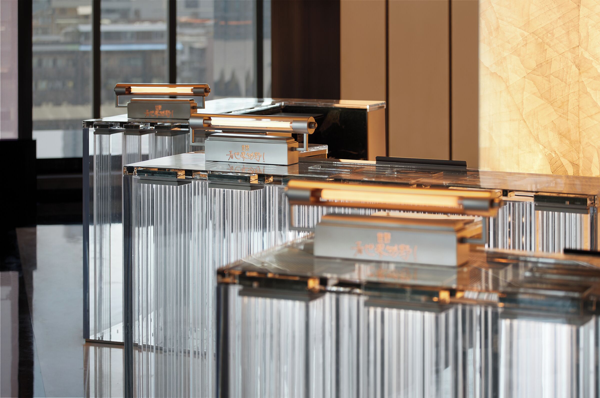 A modern interior with reflective surfaces and metallic elements, possibly a lobby or reception area.