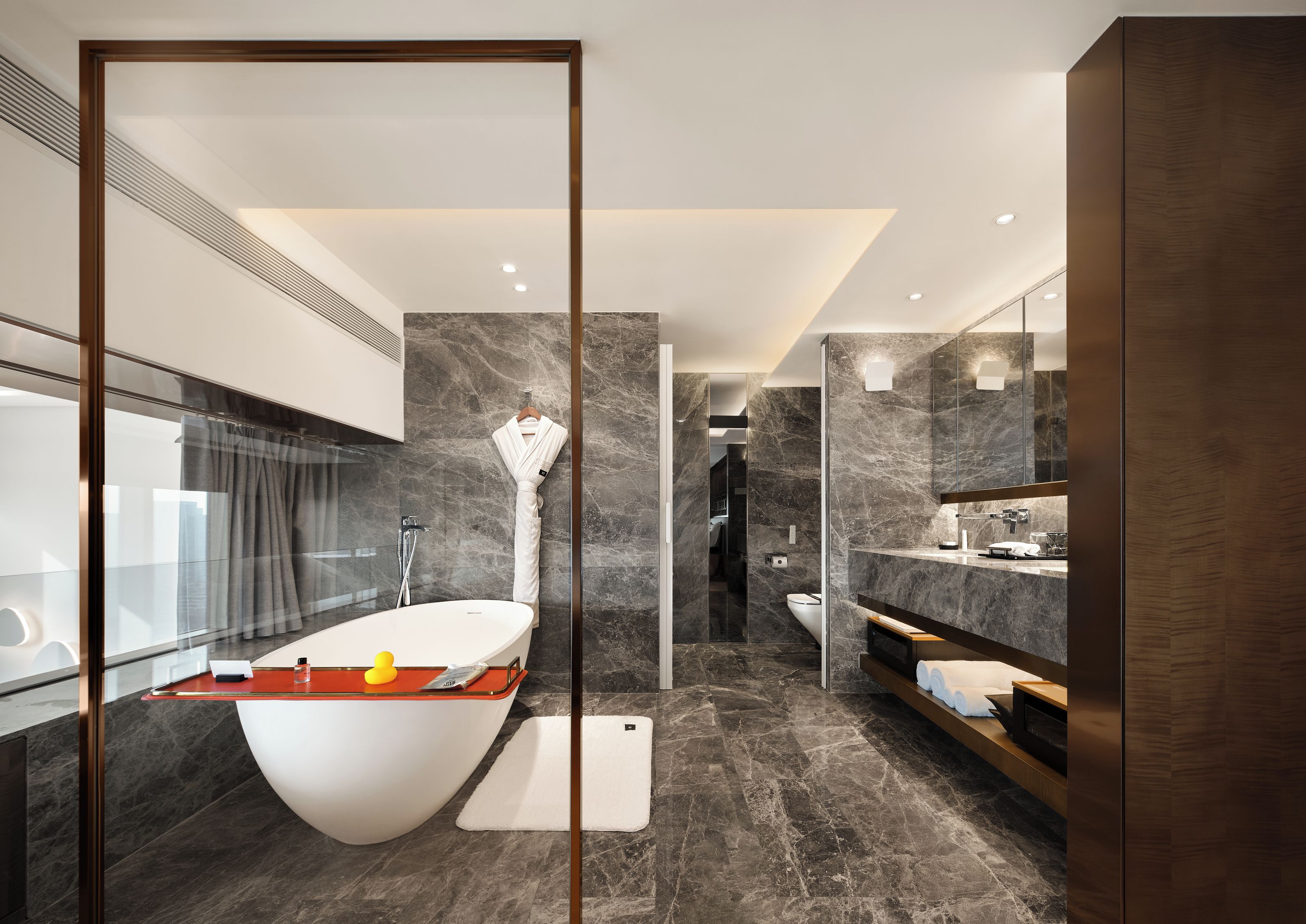 A modern bathroom with a freestanding bathtub, a glass shower enclosure, and a vanity with a mirror.