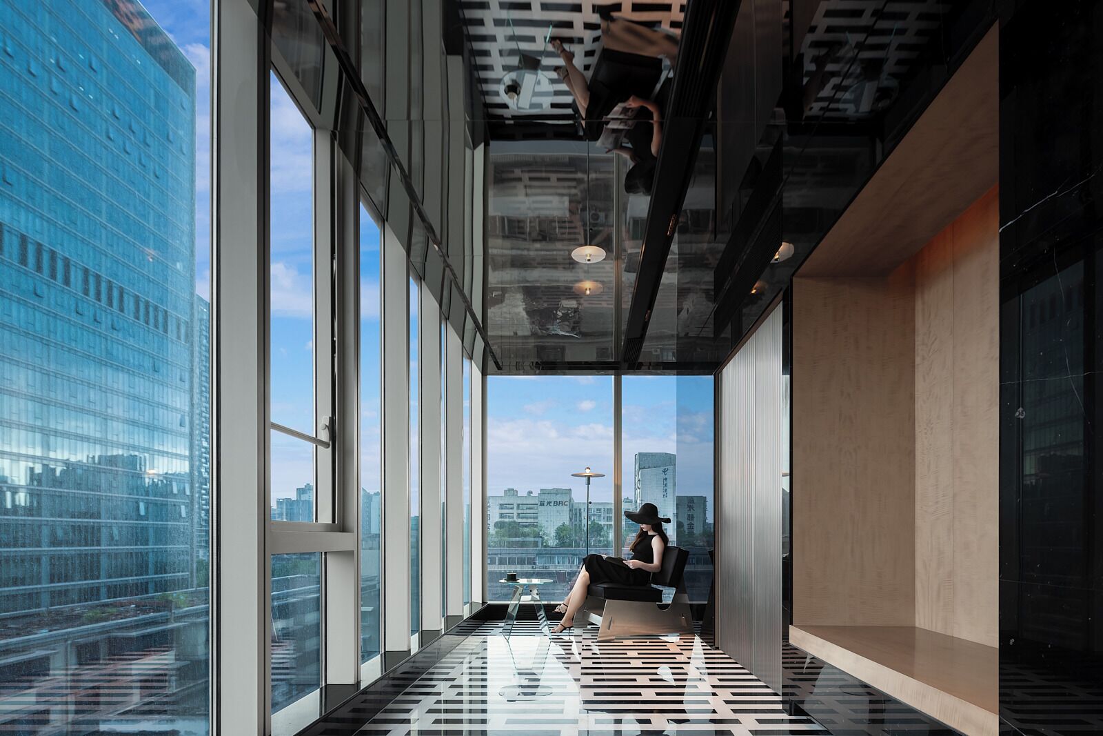 Un espacio de oficina moderno con ventanas amplias, una mesa de vidrio y vistas de la ciudad.