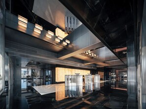 A modern interior with a high ceiling, reflective surfaces, and a central seating area with a marble table. - SEYA Serviced Apartment - Chengdu Taikoo Li Flagship - Managed by SEYA GROUP (Chengdu)