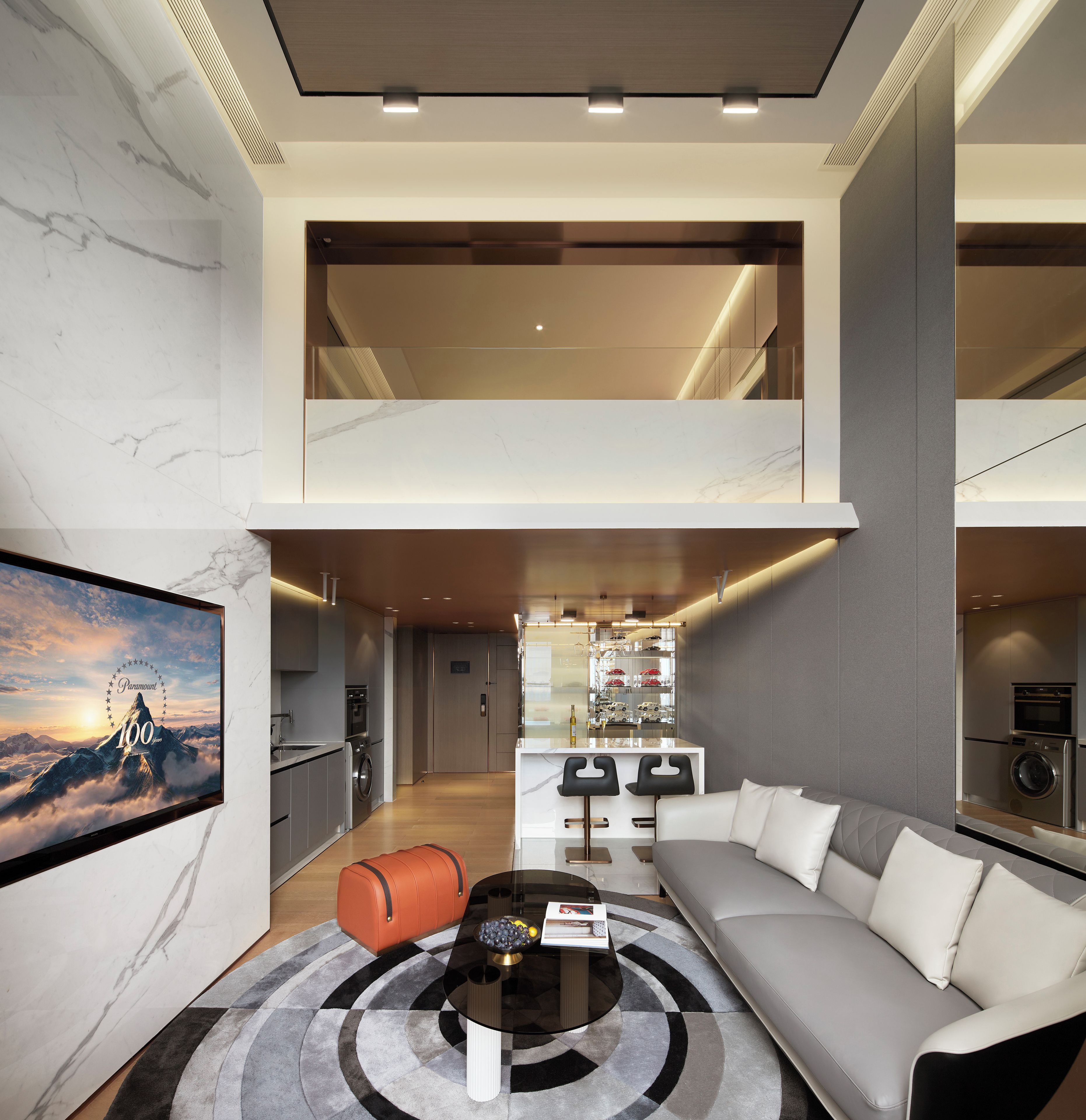 Una sala moderna con sofá, una mesa de centro y vistas a una cocina y comedor.