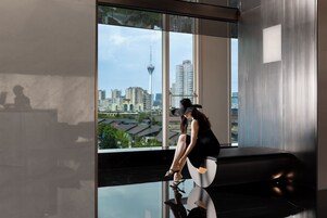 Un interior moderno con un amplio ventanal que ofrece vistas de la ciudad, un suelo reflectante y una zona de estar.