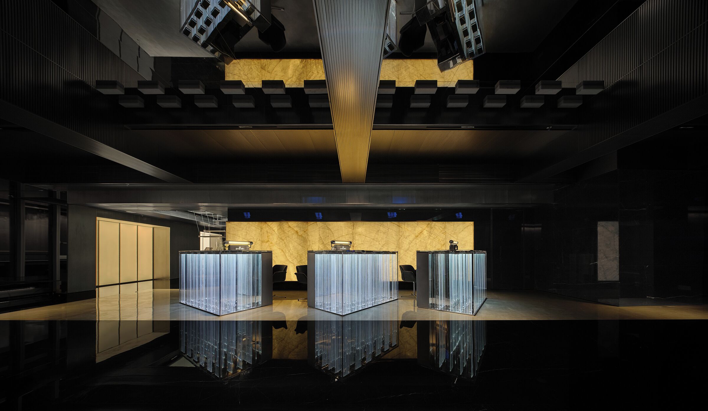 A modern interior with a reflective floor, a central seating area with a marble wall, and a unique ceiling design.