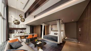 Une chambre d’hôtel moderne comprenant un coin repas, un ensemble de canapés, un lit à baldaquin et une petite table sur laquelle est posé un panier de fruits.