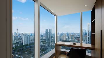A modern room with large windows, a desk, and a chair.