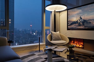 Una sala de estar moderna con vistas a la ciudad, una chimenea y un espacio de descanso acogedor.