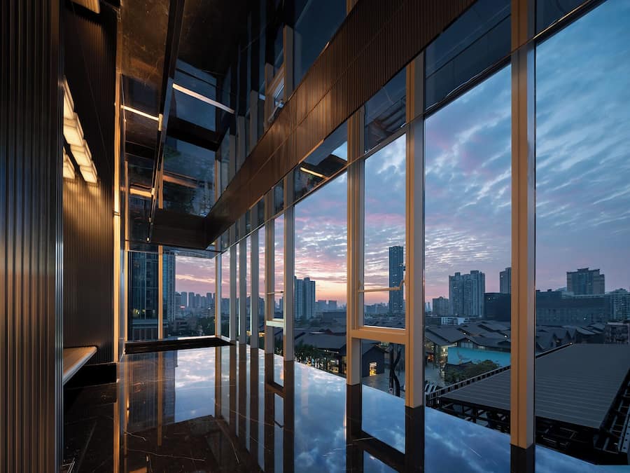 A modern interior with large windows offering a city skyline view.