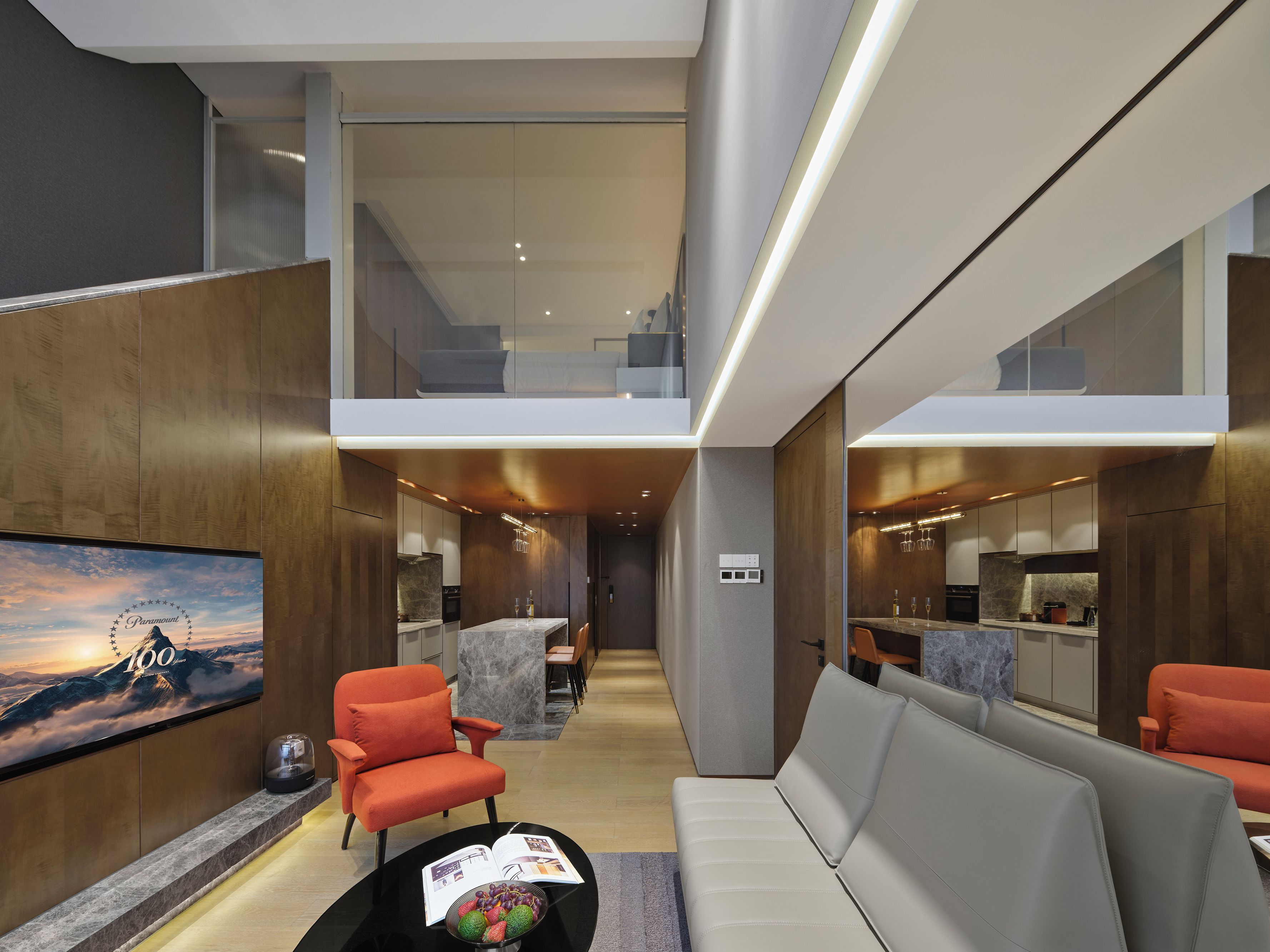 A modern interior with a sofa, armchairs, a dining area, and a kitchen.