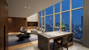 Ein modernes Wohnzimmer mit einer gebogenen Couch, einem Essbereich mit einem Marmortisch und großen Fenstern mit Blick auf die Stadt.