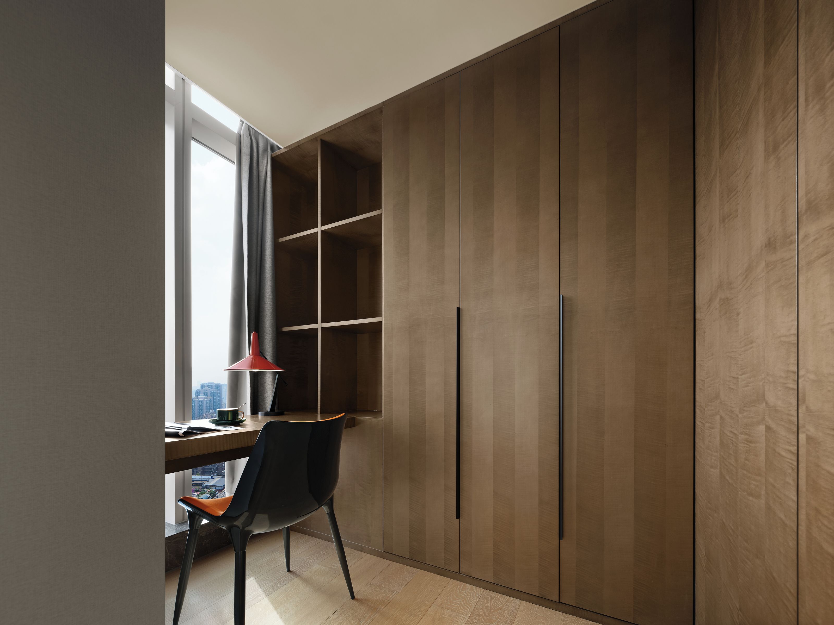 A modern room with a desk, chair, and wardrobe.