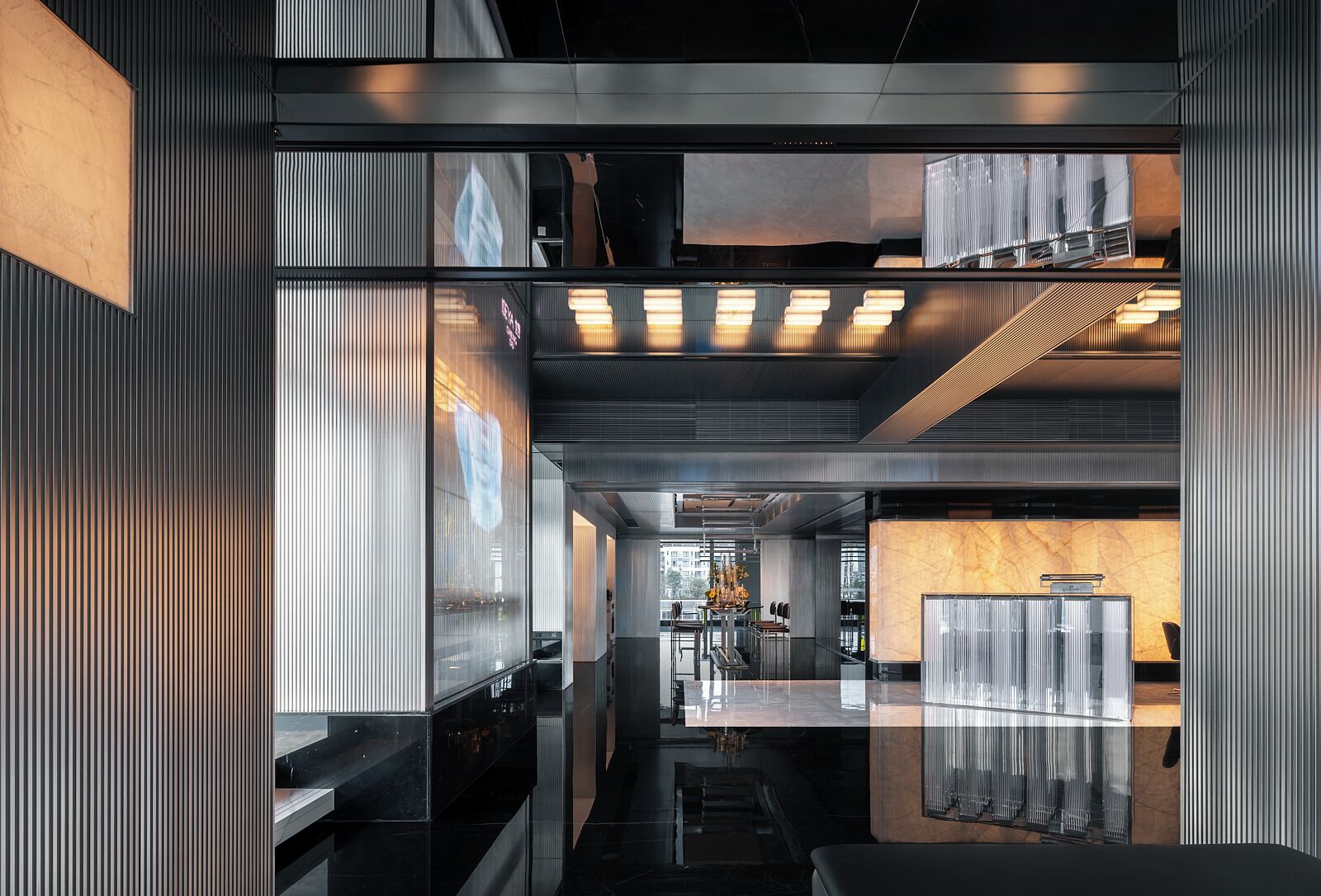 Een modern interieur met een centrale gang, reflecterende oppervlakken en een zithoek met een marmeren aanrecht.