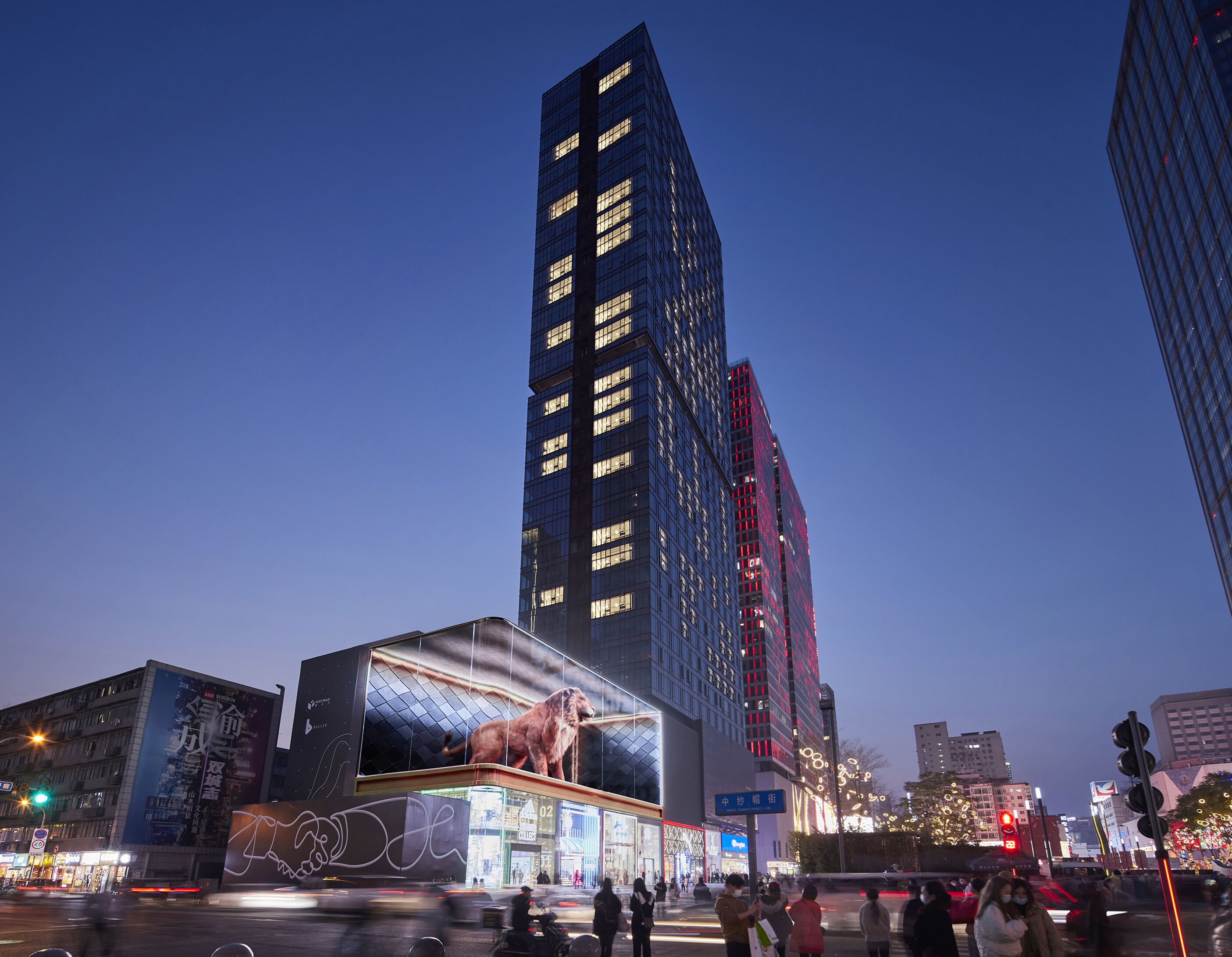 A cityscape with a prominent building featuring a large digital advertisement.