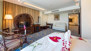 A hotel room with a bed, a TV, a desk, a chair, and a sofa. - Ocean Pearl Resort Cox's Bazar (Cox's Bazar)