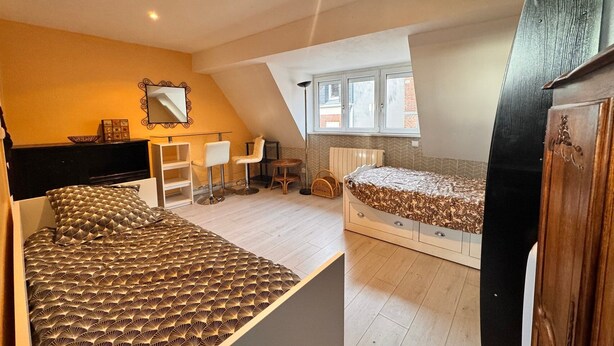 Une chambre à coucher comprenant un lit, un bureau, une chaise, une commode et une fenêtre.