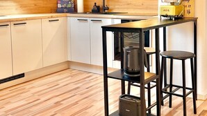 Una cucina moderna con un lucernario, mobili in legno, un piano di lavoro nero e uno sgabello da bar.
