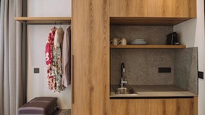 A compact kitchenette with a sink, a coffee maker, and a shelf with plates and cups. - Chania Mocenigo Luxury Room I - Seaview,15m to sea (Chania)