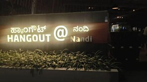 A sign with the text "HANGOUT @ Nandi" in English and another language. - Hangout at  Nandi Hills (Devanahalli)