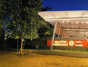 A modern building with a sign that reads "HANGOUT @ Nandi" in English and another language.