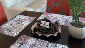 Een eettafel met een decoratief middelpunt, een potplant en een wandplank met een plant.