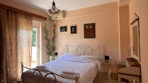 Een slaapkamer met een bed, een bureau, een stoel en een spiegel.