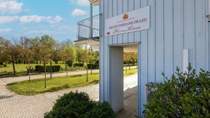 Ein Gebäude mit einem Schild für 'Klinik Rosenhof Physiotherapie-Praktik Haus am Kurbark'.