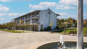 Ein Gebäude mit einer flachen Dachterrasse, mehreren Balkonen und einem Schild, das es als Hotel kennzeichnet.