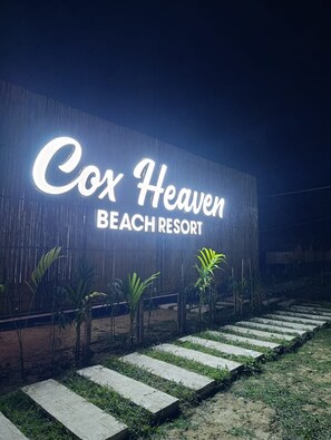 A sign for Cox Heaven Beach Resort with a modern design and a pathway leading to the entrance. - Cox Heaven Beach Resort (Cox's Bazar)