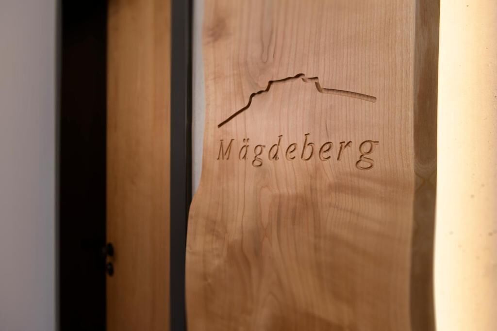 A wooden door with a carved mountain peak and the text "Mögdeberg."