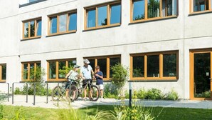A modern building with large windows and a paved area in front. - Hohentwiel Apartments (Singen)