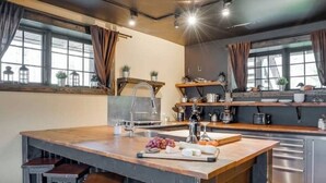 Une cuisine dotée d’un îlot central, de tabourets de bar, d’une machine à café et offrant une vue sur la ville grâce à de grandes fenêtres.
