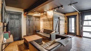 Un salon chaleureux avec un canapé en cuir, des murs en bois et une table basse en bois.